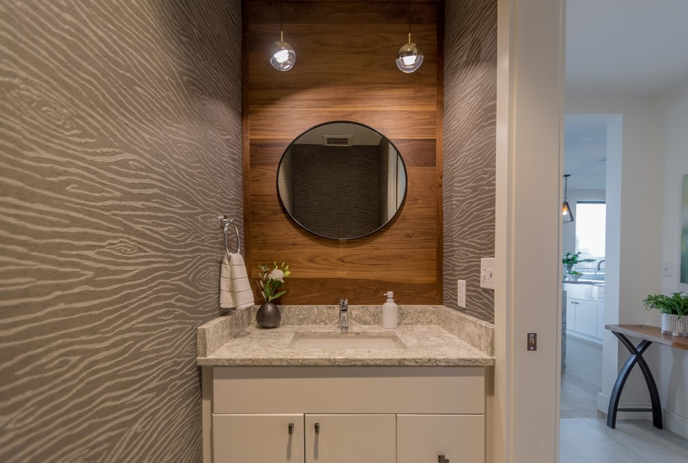 Kleine Moderne Gästetoilette mit flächenbündigen Schrankfronten, weißen Schränken, braunen Fliesen, grauer Wandfarbe, Unterbauwaschbecken, Granit-Waschbecken/Waschtisch und grauer Waschtischplatte in Portland Maine