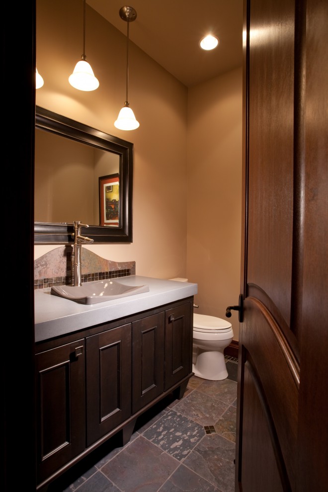 Idée de décoration pour un WC et toilettes design en bois foncé avec une vasque, un placard avec porte à panneau encastré et un carrelage marron.