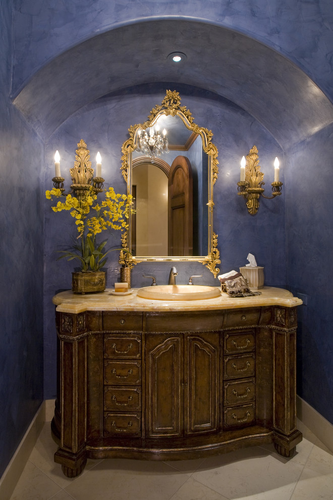 Inspiration för klassiska toaletter, med skåp i mörkt trä och blå väggar