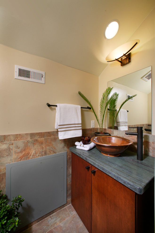 Idee per un piccolo bagno di servizio moderno con ante lisce, ante in legno bruno, WC monopezzo, piastrelle beige, piastrelle in pietra, lavabo a bacinella, top in marmo e pareti beige