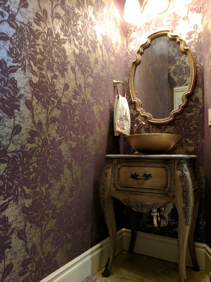 Inspiration for a small classic cloakroom in Austin with freestanding cabinets, distressed cabinets, a one-piece toilet, purple walls, travertine flooring, a vessel sink, wooden worktops and beige floors.