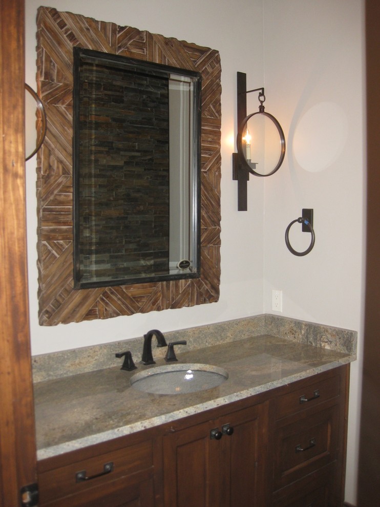 Immagine di un bagno di servizio stile rurale di medie dimensioni con ante in stile shaker, ante in legno bruno, piastrelle grigie, piastrelle in pietra, pareti beige, lavabo integrato e top in granito
