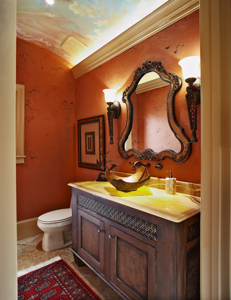 Immagine di un bagno di servizio mediterraneo con lavabo a bacinella, ante con riquadro incassato, ante in legno bruno e piastrelle beige