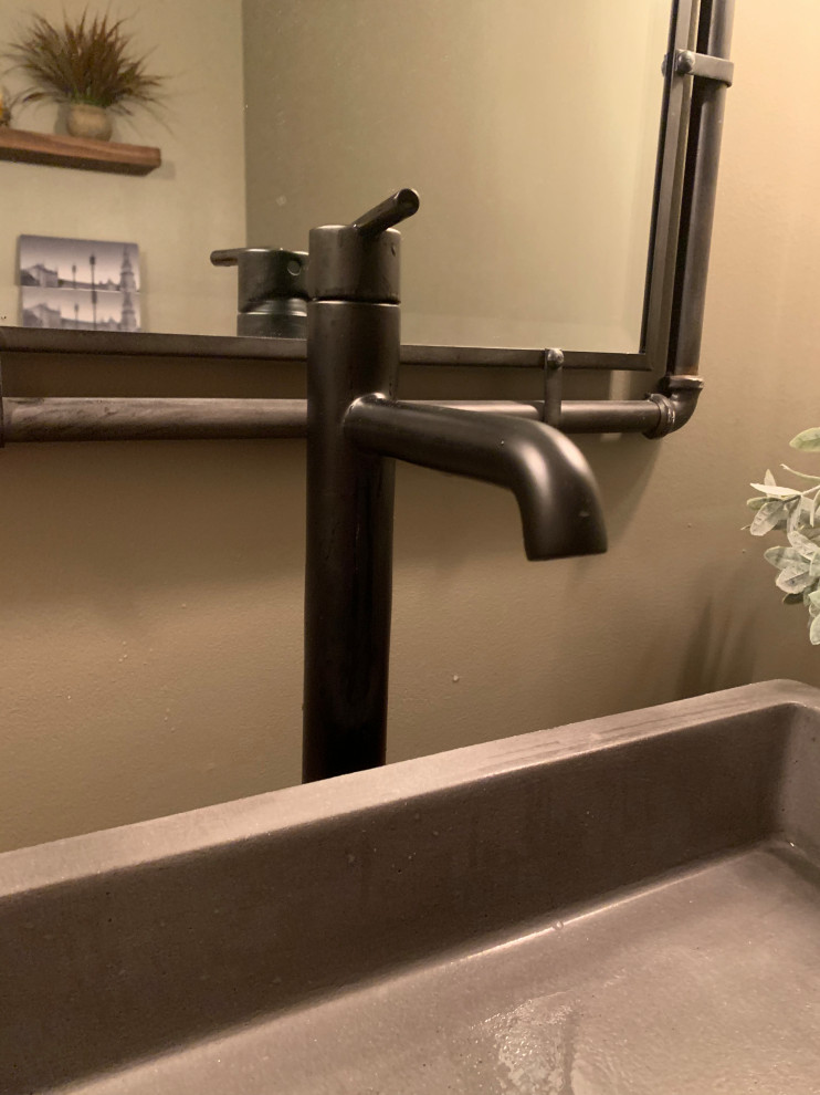 Modelo de aseo industrial de tamaño medio con paredes beige, suelo de madera clara, lavabo sobreencimera, encimera de madera, suelo marrón y encimeras marrones
