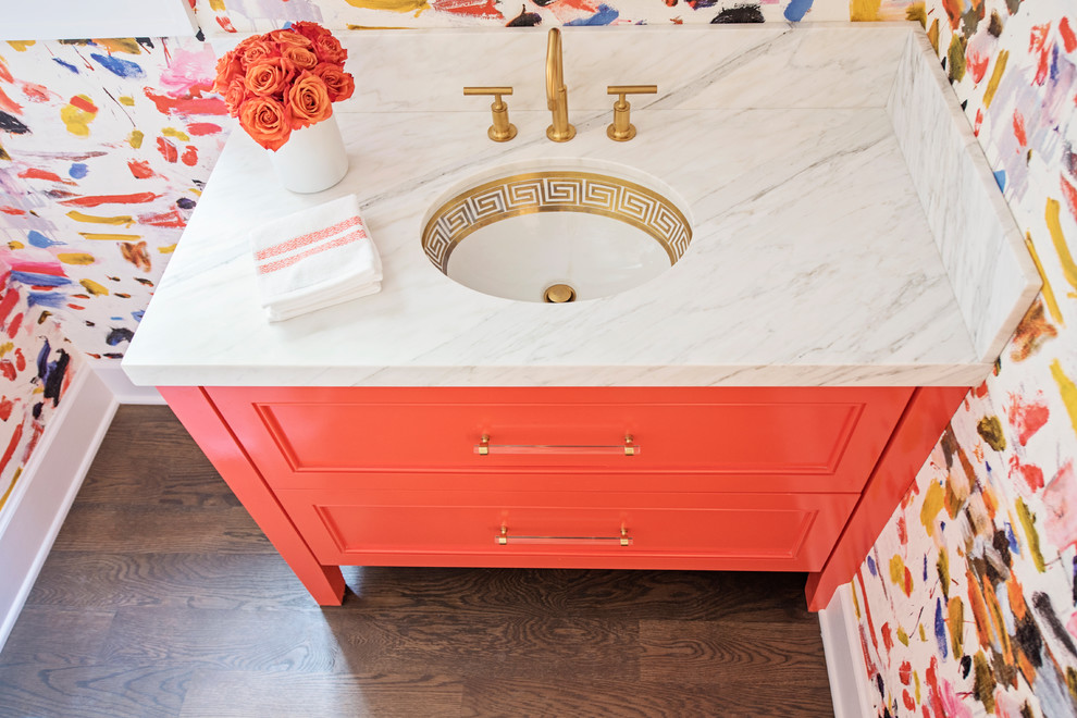 Inspiration for a small eclectic medium tone wood floor and brown floor powder room remodel in Other with flat-panel cabinets, orange cabinets, an undermount sink and marble countertops