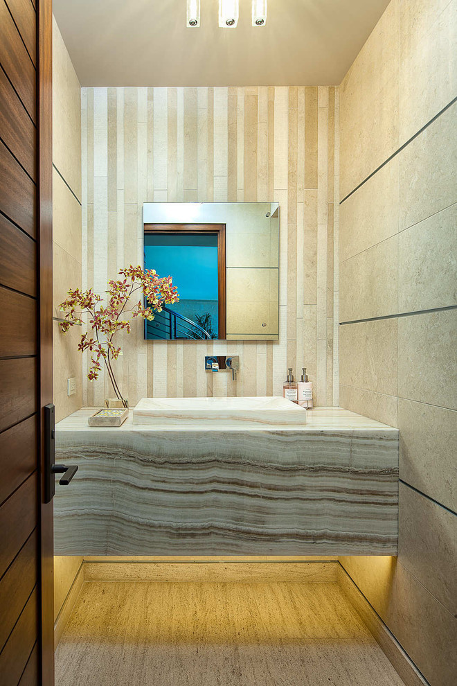 Ispirazione per un bagno di servizio design con lavabo integrato, top in onice, piastrelle beige, pavimento in pietra calcarea e piastrelle di pietra calcarea