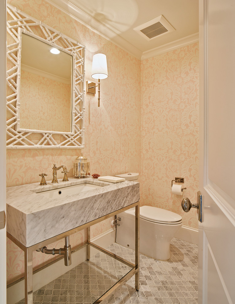 Inredning av ett klassiskt mellanstort toalett, med en toalettstol med separat cisternkåpa, grå kakel, stenkakel, rosa väggar, marmorgolv, marmorbänkskiva, öppna hyllor, ett konsol handfat och grått golv