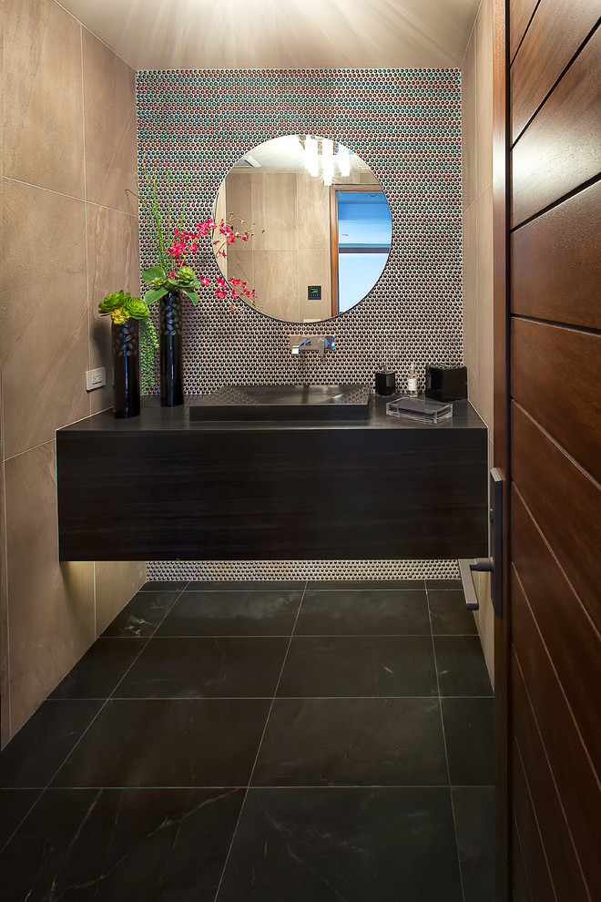 Inspiration for a medium sized contemporary cloakroom in Orange County with an integrated sink, granite worktops, porcelain tiles, marble flooring, beige tiles and black worktops.