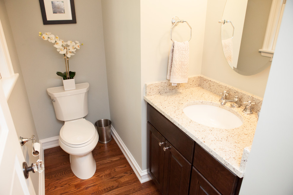 Small elegant medium tone wood floor powder room photo in Chicago with an undermount sink, dark wood cabinets, granite countertops, raised-panel cabinets and a two-piece toilet