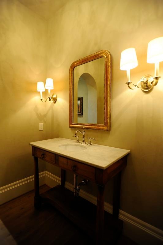 Mid-sized tuscan medium tone wood floor powder room photo in Other with medium tone wood cabinets, beige walls and marble countertops