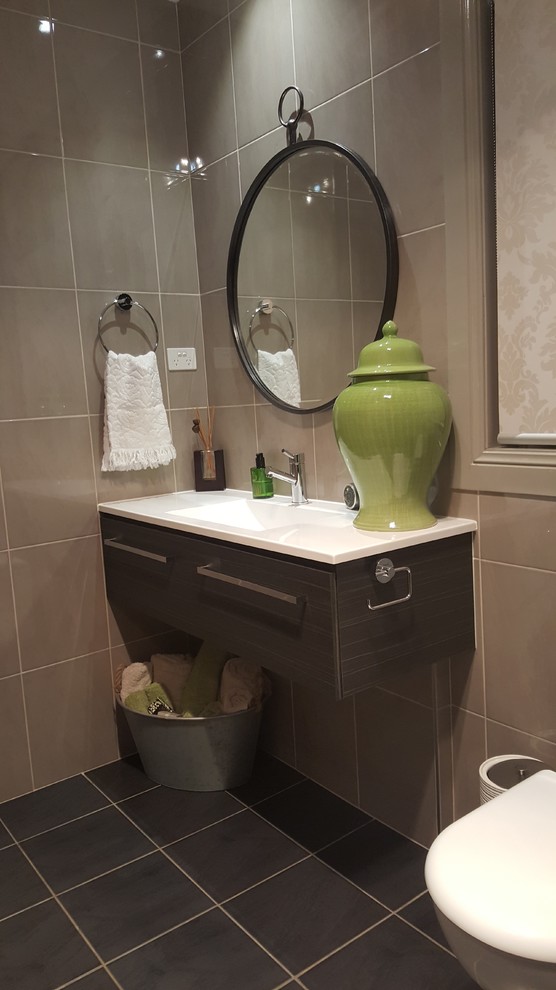 Kleine Gästetoilette mit Toilette mit Aufsatzspülkasten, beigen Fliesen, Keramikfliesen, beiger Wandfarbe, Keramikboden, integriertem Waschbecken und schwarzem Boden in Sydney