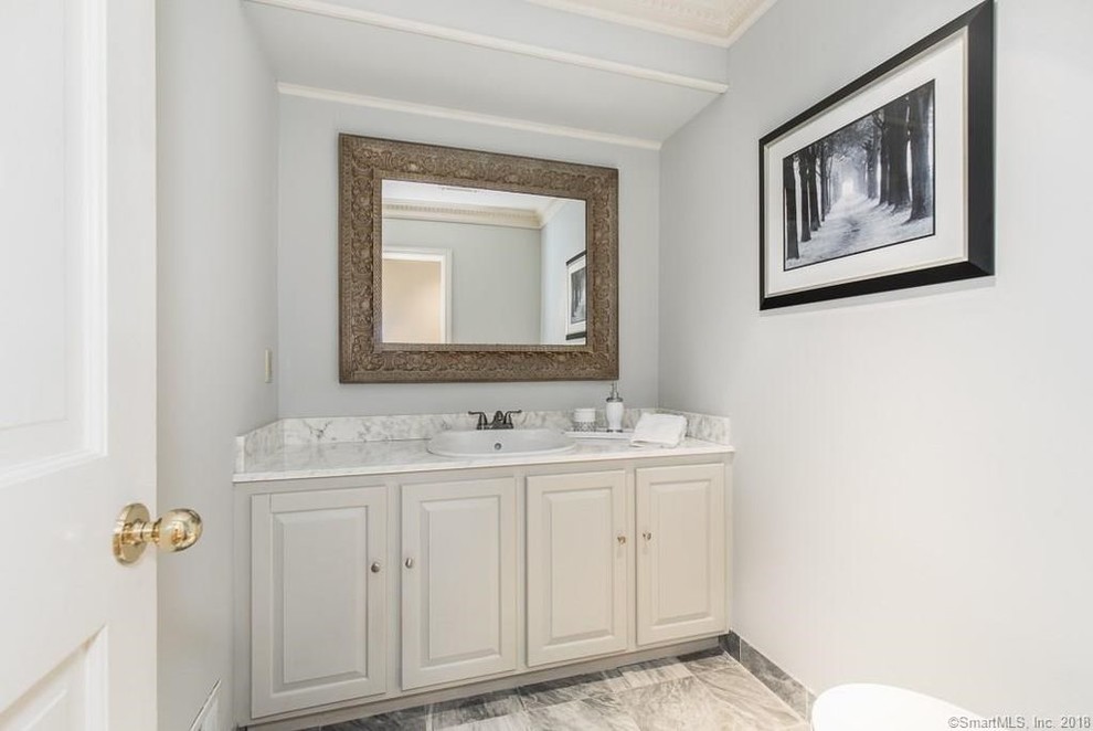 Immagine di un piccolo bagno di servizio chic con ante con bugna sagomata, ante grigie, pareti grigie, lavabo da incasso, top in quarzite, pavimento grigio e top bianco