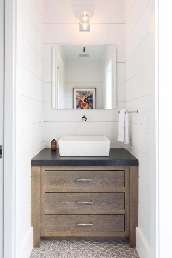 На фото: туалет в стиле модернизм с плоскими фасадами, темными деревянными фасадами, белыми стенами, полом из керамической плитки, настольной раковиной, столешницей из бетона, серым полом и черной столешницей с