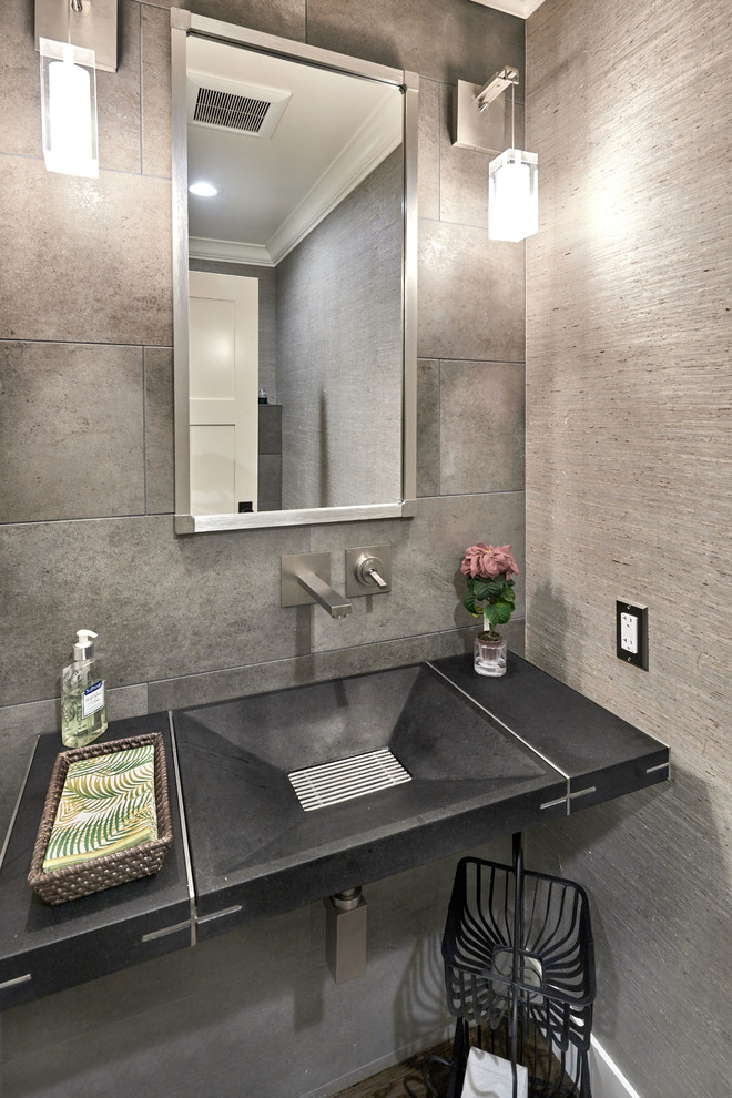 Immagine di un piccolo bagno di servizio contemporaneo con WC sospeso, piastrelle grigie, piastrelle in gres porcellanato, pareti grigie, pavimento in gres porcellanato, lavabo integrato e top in cemento