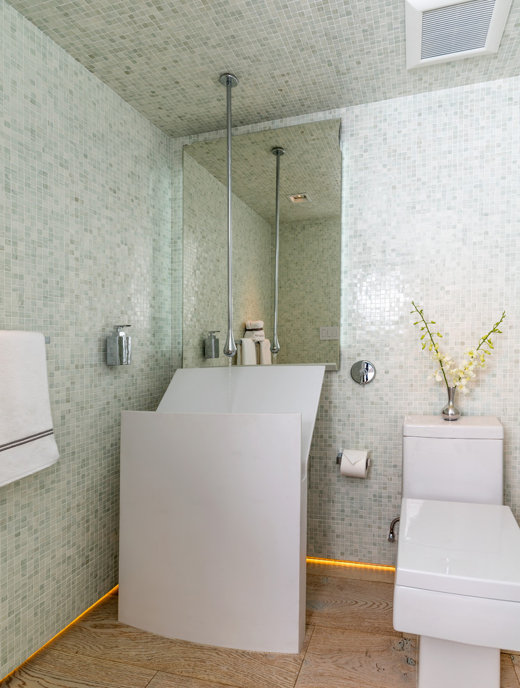 Пример оригинального дизайна: туалет среднего размера в стиле модернизм с раковиной с пьедесталом, унитазом-моноблоком, белой плиткой, светлым паркетным полом и плиткой мозаикой