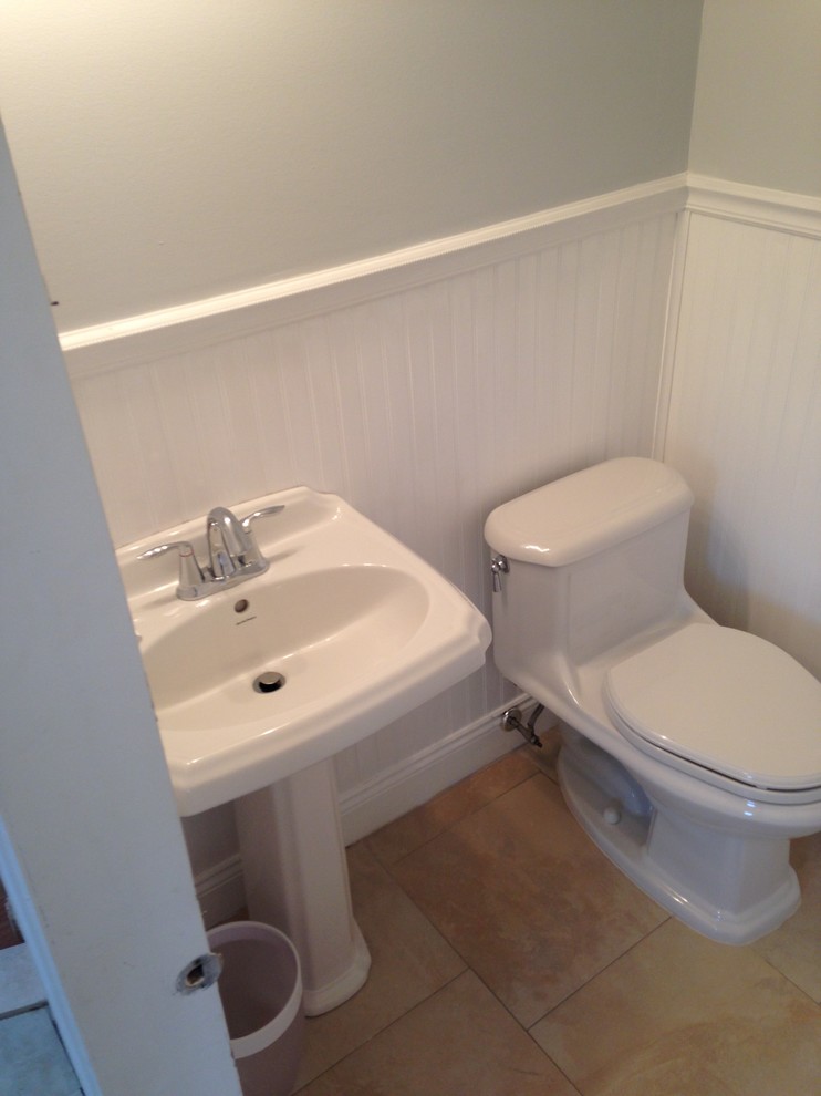 Inspiration for a small coastal cloakroom in New York with grey walls, porcelain flooring, a pedestal sink, solid surface worktops and beige floors.