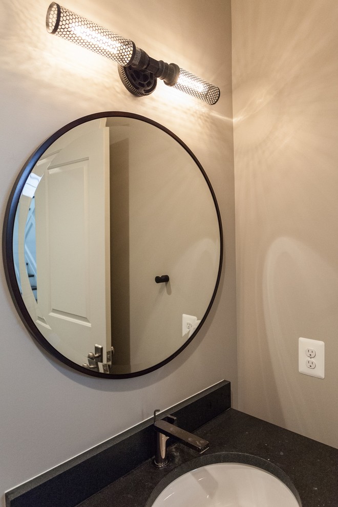 Esempio di un bagno di servizio classico con consolle stile comò, ante in legno bruno, WC a due pezzi, pareti beige, lavabo sottopiano, pavimento grigio e top nero