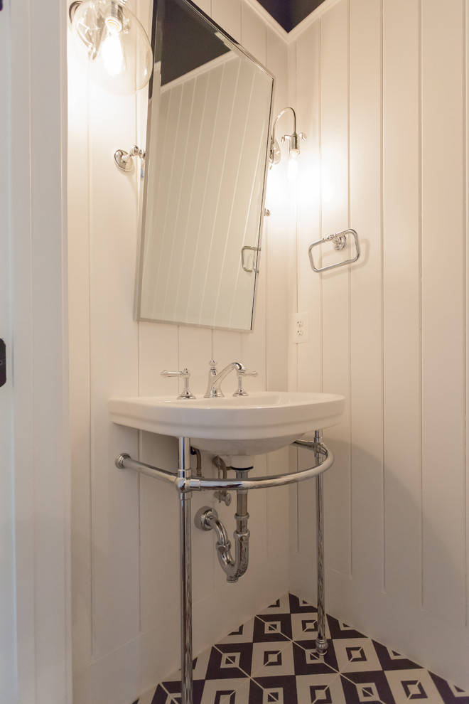 This is an example of a classic cloakroom in DC Metro with white walls, porcelain flooring and a pedestal sink.