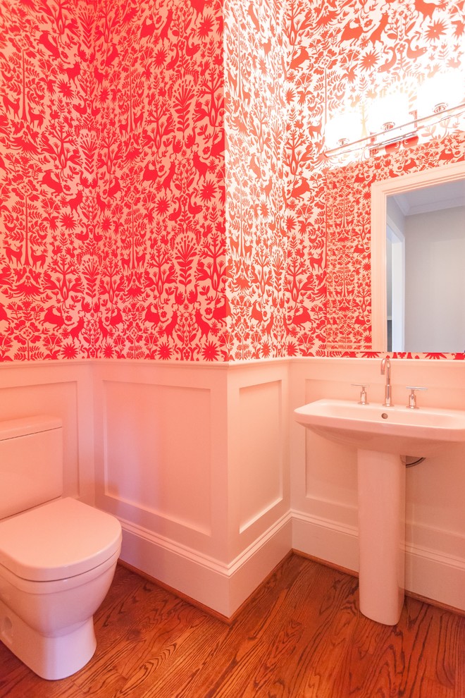 Источник вдохновения для домашнего уюта: туалет в стиле кантри с розовыми стенами, паркетным полом среднего тона, раковиной с пьедесталом и коричневым полом