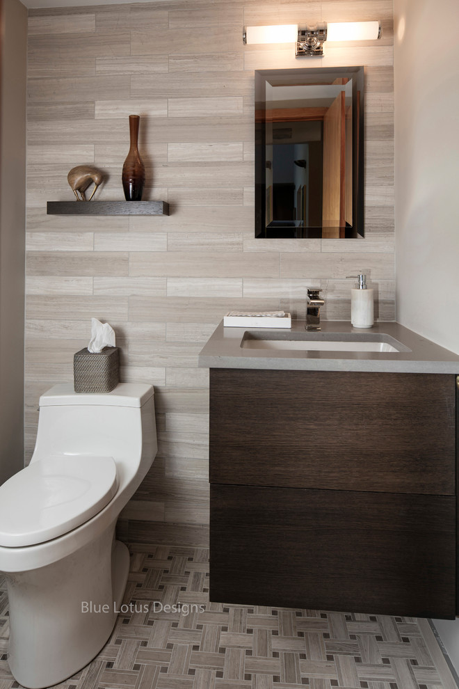 This is an example of a small traditional cloakroom in Philadelphia with flat-panel cabinets, medium wood cabinets, a one-piece toilet, multi-coloured tiles, limestone tiles, grey walls, porcelain flooring, a submerged sink, engineered stone worktops and multi-coloured floors.
