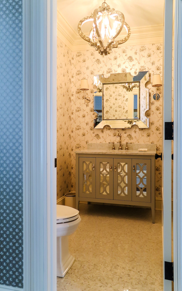 Example of a mid-sized transitional beige tile porcelain tile powder room design in New York with an undermount sink, glass-front cabinets, gray cabinets, marble countertops, a one-piece toilet and multicolored walls