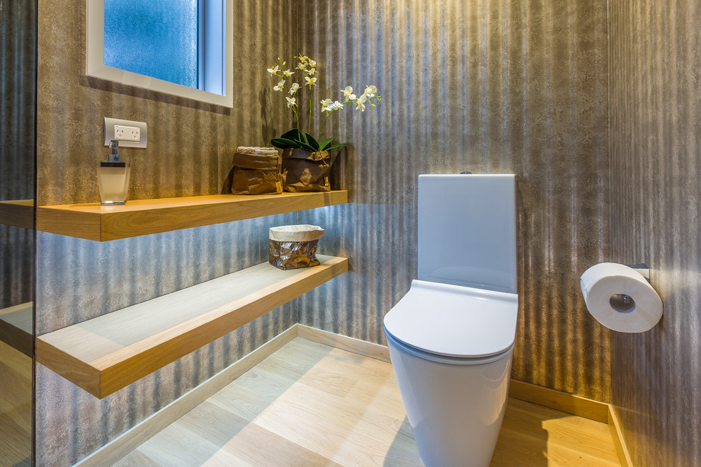 Kleine Industrial Gästetoilette mit offenen Schränken, hellen Holzschränken, Wandtoilette mit Spülkasten, brauner Wandfarbe, hellem Holzboden, Sockelwaschbecken und Waschtisch aus Holz in Auckland