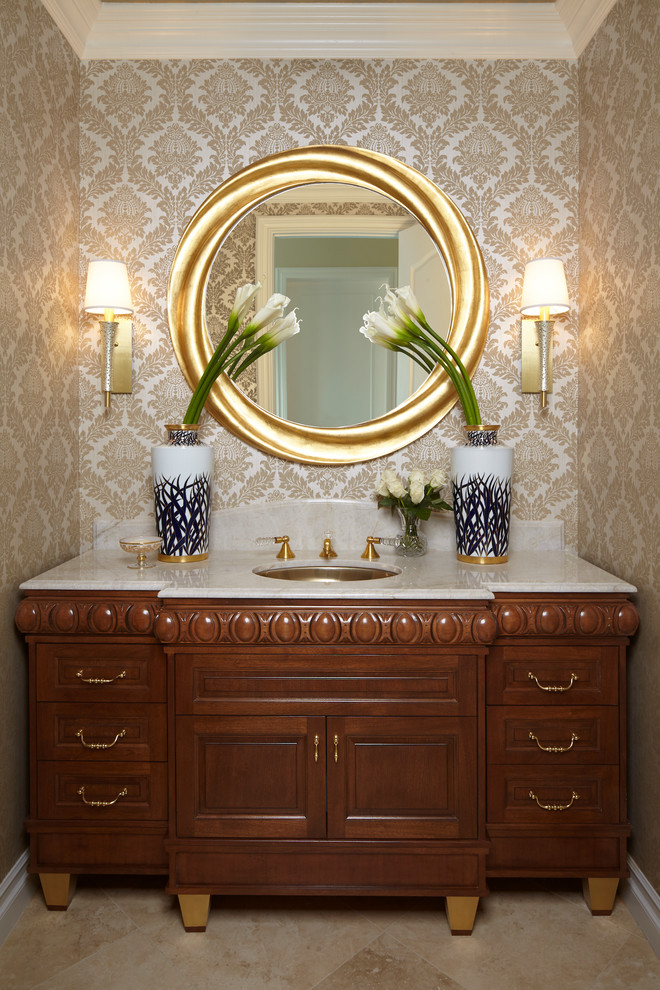 Idée de décoration pour un WC et toilettes tradition en bois brun de taille moyenne avec un placard en trompe-l'oeil, un mur beige, un sol en travertin, un lavabo encastré, un plan de toilette en marbre et un sol beige.