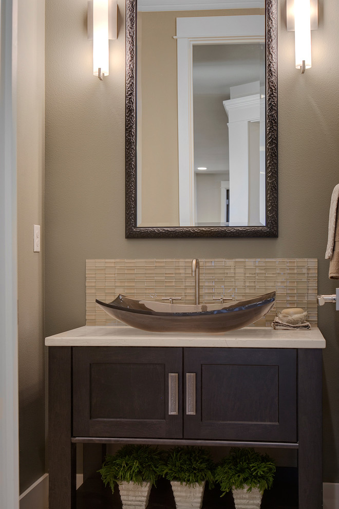 Exemple d'un WC et toilettes tendance en bois foncé avec une vasque, un placard en trompe-l'oeil, un plan de toilette en marbre, un carrelage beige, un carrelage en pâte de verre et un mur gris.