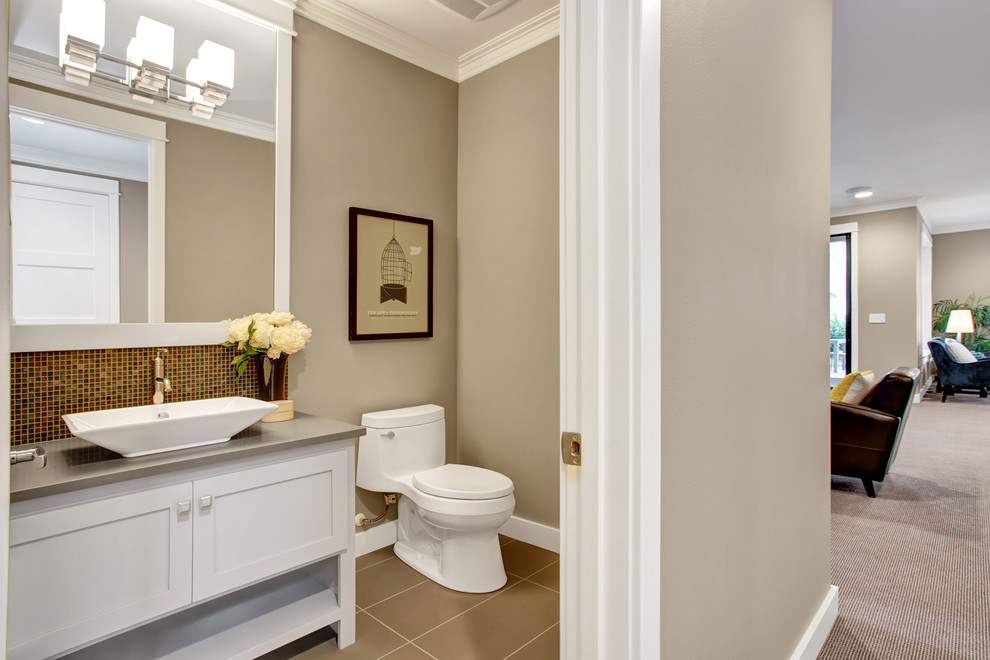 Idéer för amerikanska toaletter, med skåp i shakerstil, vita skåp, en toalettstol med hel cisternkåpa, mosaik, beige väggar, klinkergolv i porslin, ett fristående handfat, bänkskiva i kvarts och brun kakel