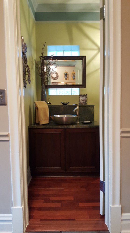 Exemple d'un WC et toilettes chic avec un placard à porte shaker, des portes de placard marrons, un mur multicolore, un sol en bois brun, une vasque, un plan de toilette en granite et WC séparés.