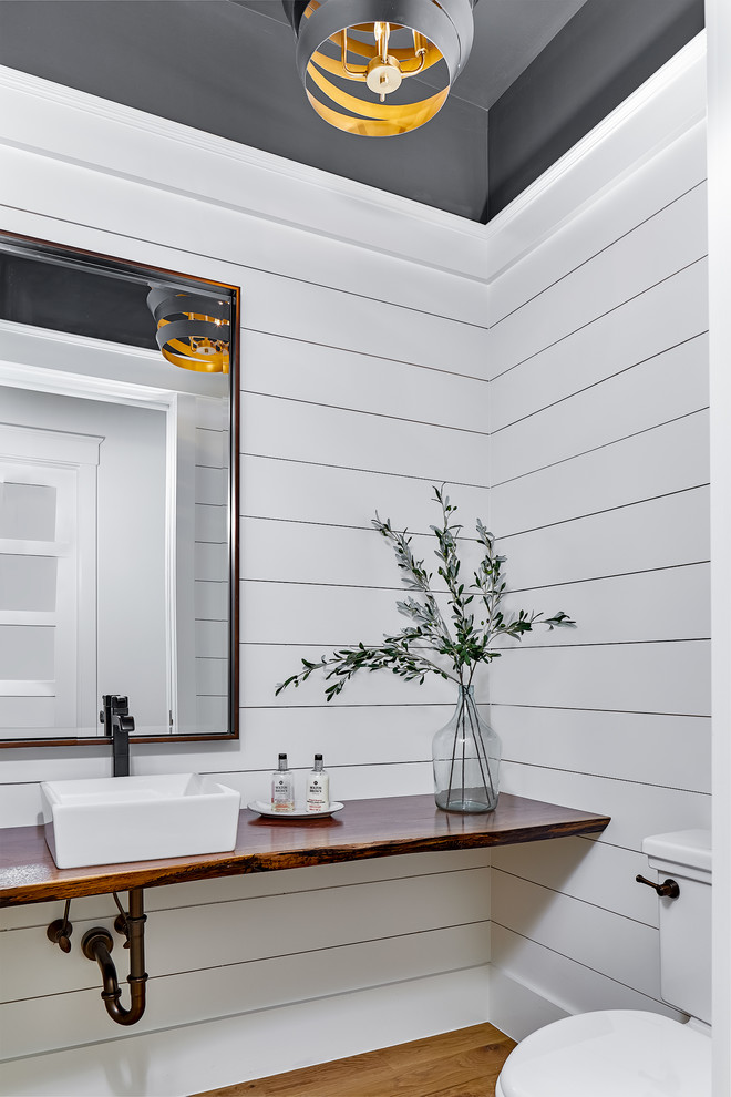 Imagen de aseo marinero de tamaño medio con paredes blancas, suelo de madera en tonos medios, lavabo sobreencimera, encimera de madera y suelo marrón