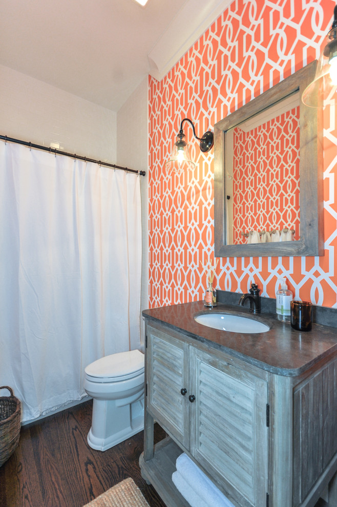 Example of a trendy powder room design in Atlanta with blue cabinets and orange walls