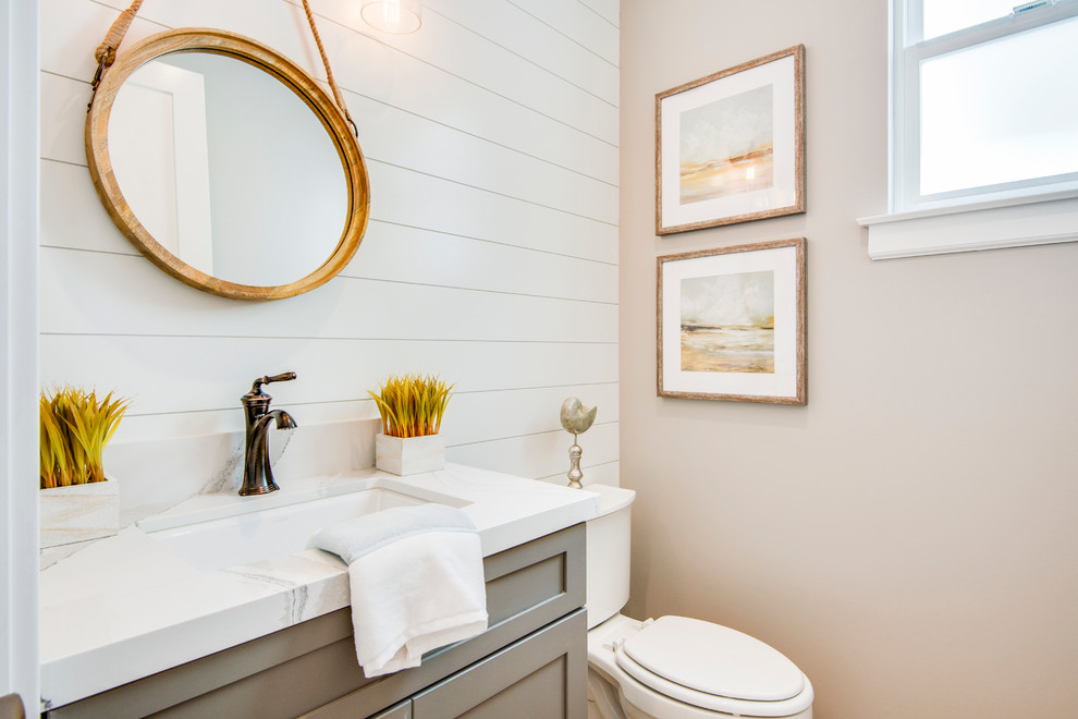 Idée de décoration pour un petit WC et toilettes marin avec un placard à porte shaker, des portes de placard grises, WC séparés, un lavabo encastré, un plan de toilette en quartz modifié, un mur beige et un plan de toilette blanc.
