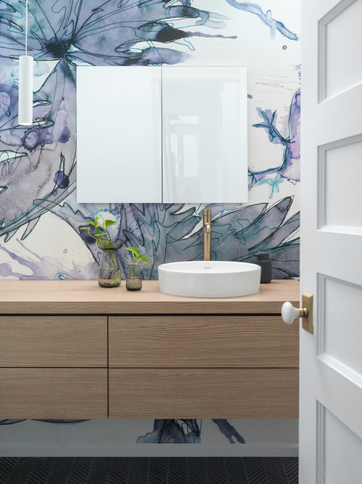 Inspiration for a contemporary cloakroom in New York with flat-panel cabinets, medium wood cabinets, multi-coloured walls, a vessel sink, wooden worktops, black floors, brown worktops, a floating vanity unit and wallpapered walls.
