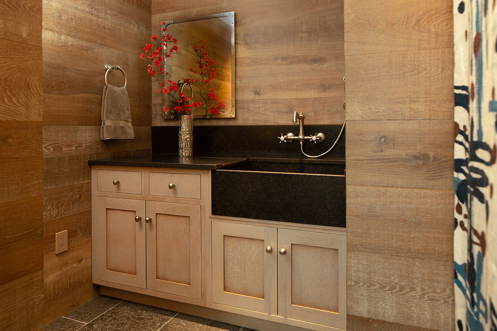 Idée de décoration pour un WC et toilettes champêtre en bois clair avec un placard à porte shaker, un mur marron, un sol gris et un plan de toilette noir.