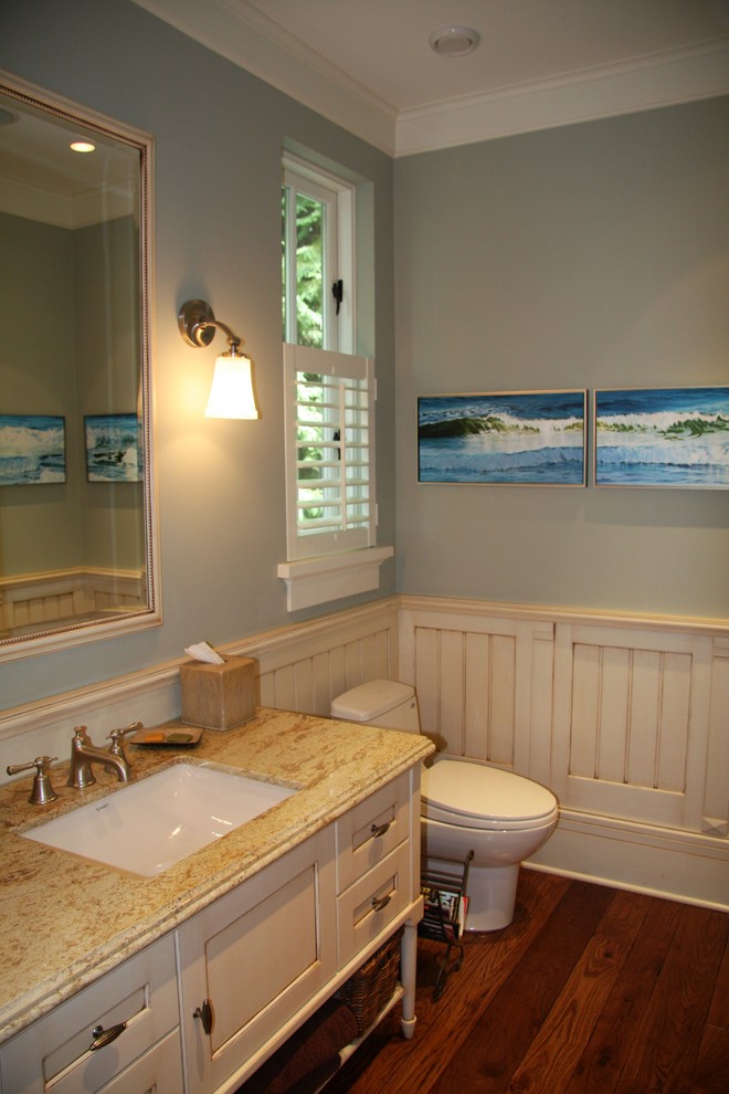 Mittelgroße Klassische Gästetoilette mit Kassettenfronten, beigen Schränken, Unterbauwaschbecken, Granit-Waschbecken/Waschtisch, Toilette mit Aufsatzspülkasten, blauer Wandfarbe und braunem Holzboden in Vancouver
