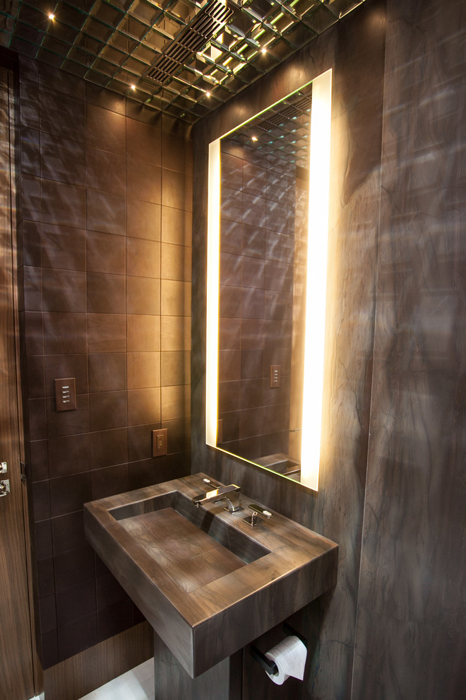 バンクーバーにあるラグジュアリーな小さなコンテンポラリースタイルのおしゃれなトイレ・洗面所 (大理石の洗面台、茶色いタイル、グレーの壁、壁付け型シンク) の写真