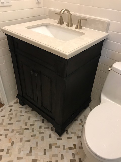 Small transitional white tile and ceramic tile beige floor powder room photo in New York with raised-panel cabinets, dark wood cabinets, a one-piece toilet, beige walls and an undermount sink