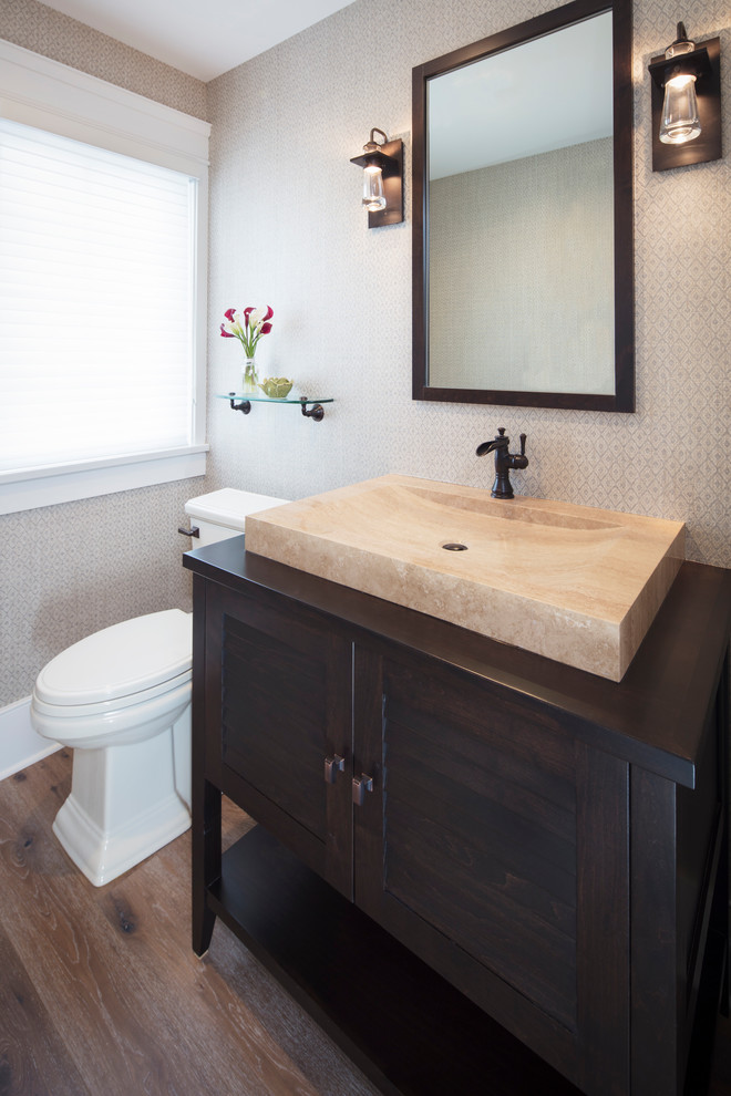 Foto på ett litet vintage toalett, med ett fristående handfat, träbänkskiva, skåp i shakerstil, skåp i mörkt trä, en toalettstol med separat cisternkåpa, beige väggar, mörkt trägolv och brunt golv