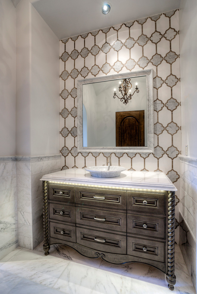Powder room - mid-sized transitional white tile powder room idea in Phoenix with furniture-like cabinets, medium tone wood cabinets, marble countertops, a vessel sink and white countertops