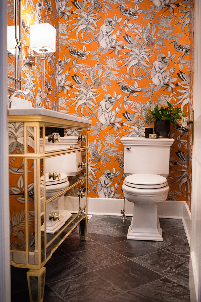 На фото: маленький туалет в стиле неоклассика (современная классика) с фасадами островного типа, раздельным унитазом, оранжевыми стенами, полом из сланца, врезной раковиной, мраморной столешницей и черным полом для на участке и в саду с