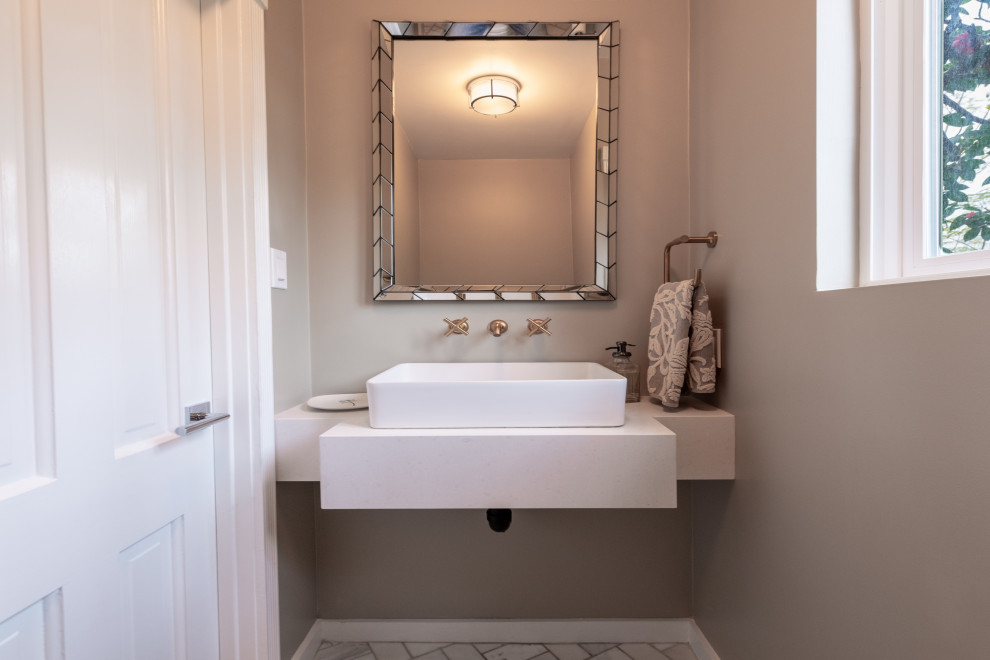 Mittelgroße Moderne Gästetoilette mit Toilette mit Aufsatzspülkasten, beiger Wandfarbe, Marmorboden, Aufsatzwaschbecken, gefliestem Waschtisch, weißem Boden, weißer Waschtischplatte, weißen Schränken und schwebendem Waschtisch in Los Angeles