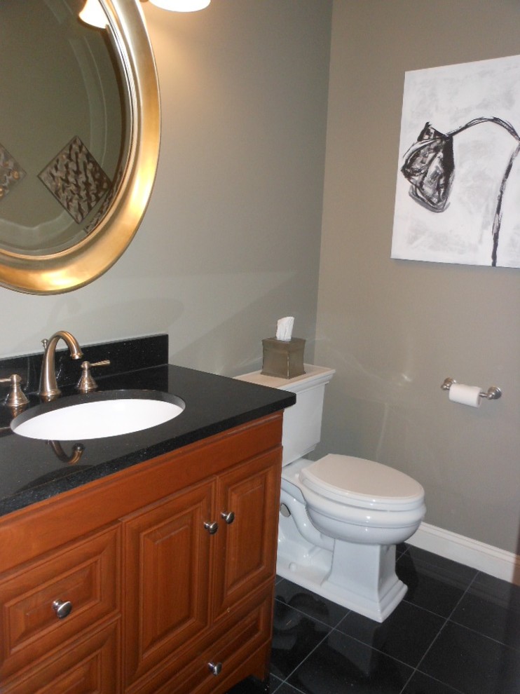 Inredning av ett modernt mellanstort toalett, med ett undermonterad handfat, luckor med upphöjd panel, skåp i mellenmörkt trä, granitbänkskiva, svart kakel och grå väggar