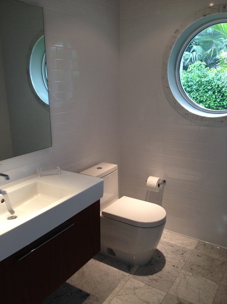 Idee per un piccolo bagno di servizio minimalista con ante lisce, ante in legno scuro, WC monopezzo, piastrelle bianche, piastrelle diamantate, pareti bianche, pavimento in marmo e lavabo sospeso