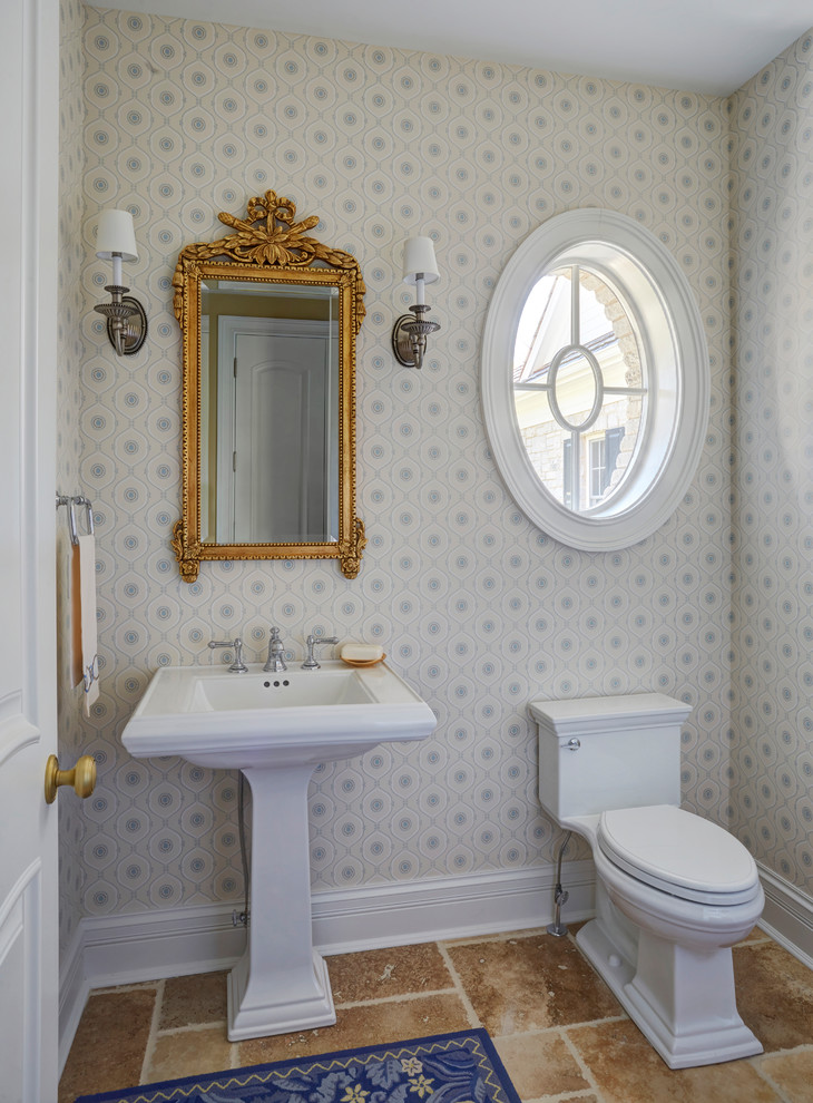 Inspiration för små klassiska toaletter, med en toalettstol med hel cisternkåpa, blå väggar, kalkstensgolv, ett piedestal handfat och brunt golv