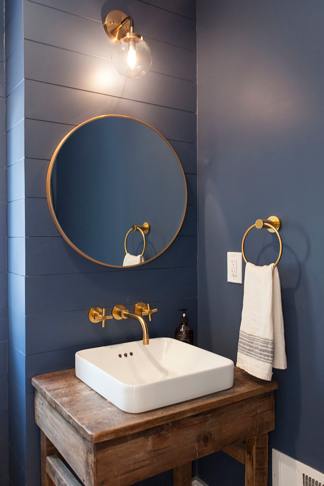 ワシントンD.C.にあるお手頃価格の小さなカントリー風のおしゃれなトイレ・洗面所 (家具調キャビネット、中間色木目調キャビネット、青い壁、ペデスタルシンク、木製洗面台、ブラウンの洗面カウンター) の写真