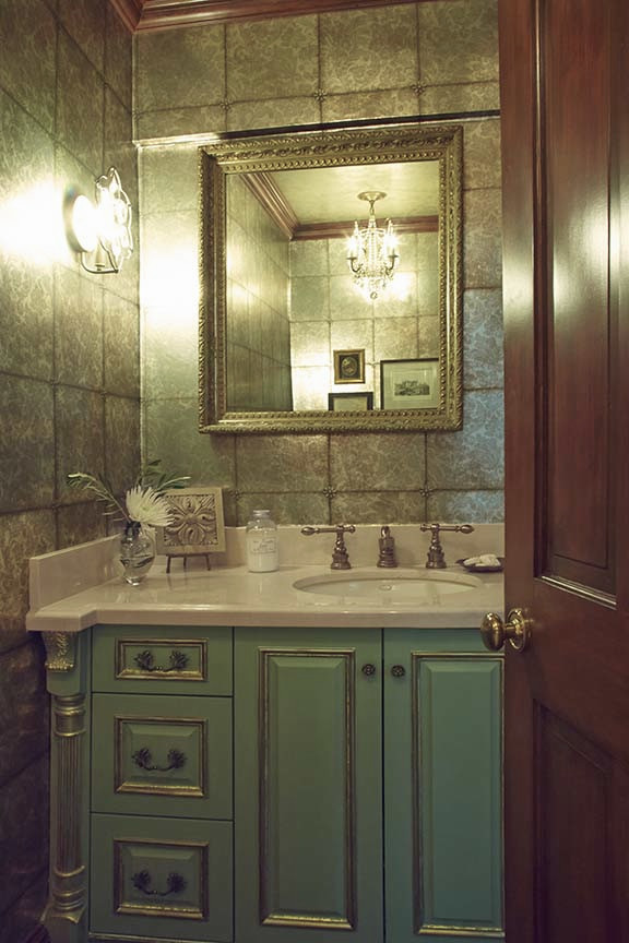 Modelo de aseo clásico pequeño con lavabo bajoencimera, armarios tipo mueble, puertas de armario verdes y encimera de mármol
