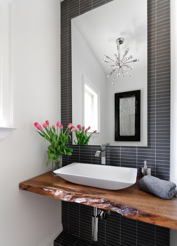Example of a trendy powder room design in Toronto with a vessel sink and brown countertops