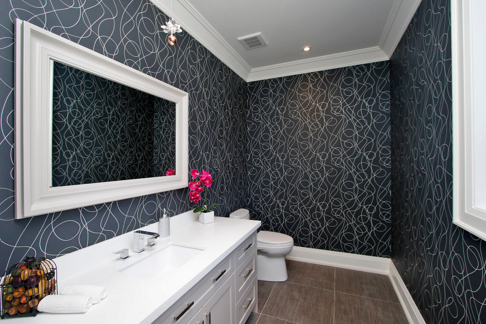 Powder room - large transitional ceramic tile and brown floor powder room idea in Toronto with white cabinets, a one-piece toilet, an undermount sink, quartz countertops, white countertops and blue walls