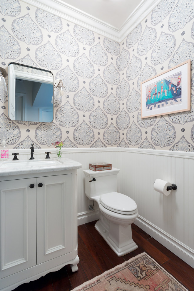 Immagine di un bagno di servizio tradizionale di medie dimensioni con ante con riquadro incassato, ante bianche, pareti multicolore, parquet scuro, lavabo sottopiano, pavimento marrone e top bianco